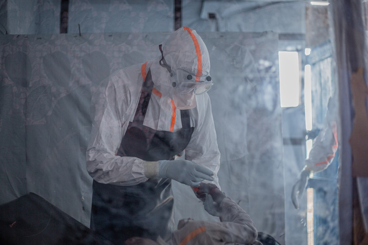 A doctor provides care to a patient with Ebola virus disease at the Rwampara Ebola Treatment Center in Bunia, Ituri, in the east of the Democratic Republic of Congo on July 13, 2026.