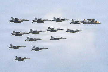 This US Navy handout photo released on July 15, 2026 and taken on June 30 by US Central Command Public Affairs shows fixed wing aircraft flying over Arleigh Burke-class guided-missile destroyer USS Frank E. Petersen Jr. during a photo exercise. The US launched a wave of strikes against Iran on July 15, after it reimposed a naval blockade in a return to war between the two foes.