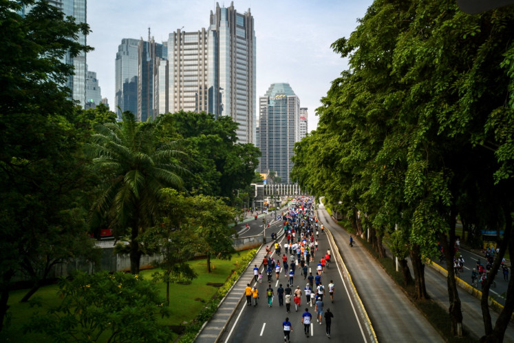People exercise on a main thoroughfare during Car Free Day in Jakarta on December 4, 2022, where select roads in the capital are closed to motorized vehicles from 6-11 am Sundays and opened to pedestrians and bicyclists. 