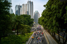 People exercise on a main thoroughfare during Car Free Day in Jakarta on December 4, 2022, where select roads in the capital are closed to motorized vehicles from 6-11 am Sundays and opened to pedestrians and bicyclists. 