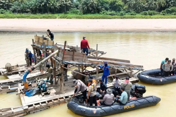 Officers from Kuantan Singingi Police raid rafts used in illegal gold mining activities on July 3 along Kuantan River in Kuantan Singingi regency, Riau. Police forces in the regency have been intensifying law enforcement against illegal mining activities in the regency. 
