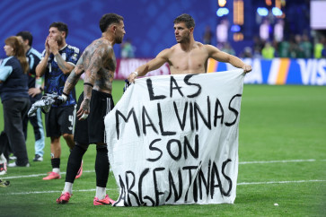 Argentina's defender #19 Nicolas Otamendi (left) and midfielder #11 Giovani Lo Celso show a banner that reads in Spanish, &ldquo;The Malvinas (Falkland Islands) belong to Argentina,&ldquo; after winning the 2026 World Cup football tournament semi-final match between England and Argentina at the Atlanta Stadium in Atlanta on July 15, 2026.  