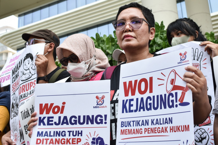 Rallygoers under the civil society coalition MBG Watch hold posters during a rally in front of the Attorney General's Office (AGO) building in South Jakarta on July 15, 2026. The protesters urged the AGO to completely investigate alleged corruption pertaining to President Prabowo Subianto's flagship free nutritious meal program.