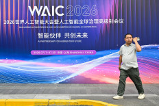 A man walks past signage for the World Artificial Intelligence Conference (WAIC) in Shanghai on July 16, 2026.