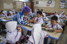Members of the Cimahi Clown Community distribute free meals to new students during the school orientation program at the SDN Cibeber elementary school complex in Cimahi, West Java, on July 14, 2026. The community organized entertainment, motivational activities and educational sessions on the &ldquo;Seven Habits of Great Indonesian Children&ldquo; while promoting the government's free meals program to help new students feel safe and welcome. 