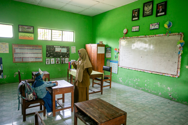 A teacher teaches a new pupil during a school orientation program at SD Cepokosawit II state elementary school in Boyolali, Central Java, on July 13, 2026. The Boyolali Education Agency is discussing a plan to merge the school with others that have seen low enrollment during this academic year to maintain the quality of education.