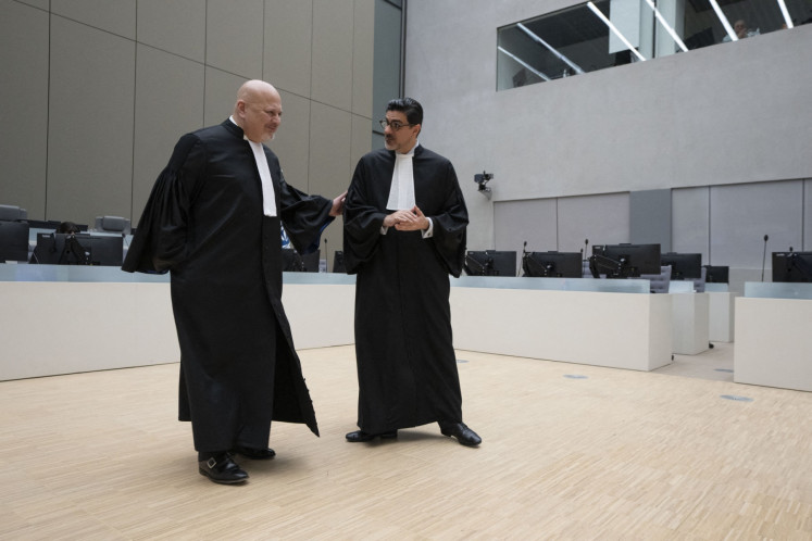 Chief Prosecutor Karim Khan (left) talks to registrar Osvaldo Zavala Giler (right) prior to the first appearance of former Philippine president Rodrigo Duterte before the International Criminal Court (ICC) on charge of crimes against humanity over his deadly crackdown on narcotics, in The Hague on March 14, 2025.