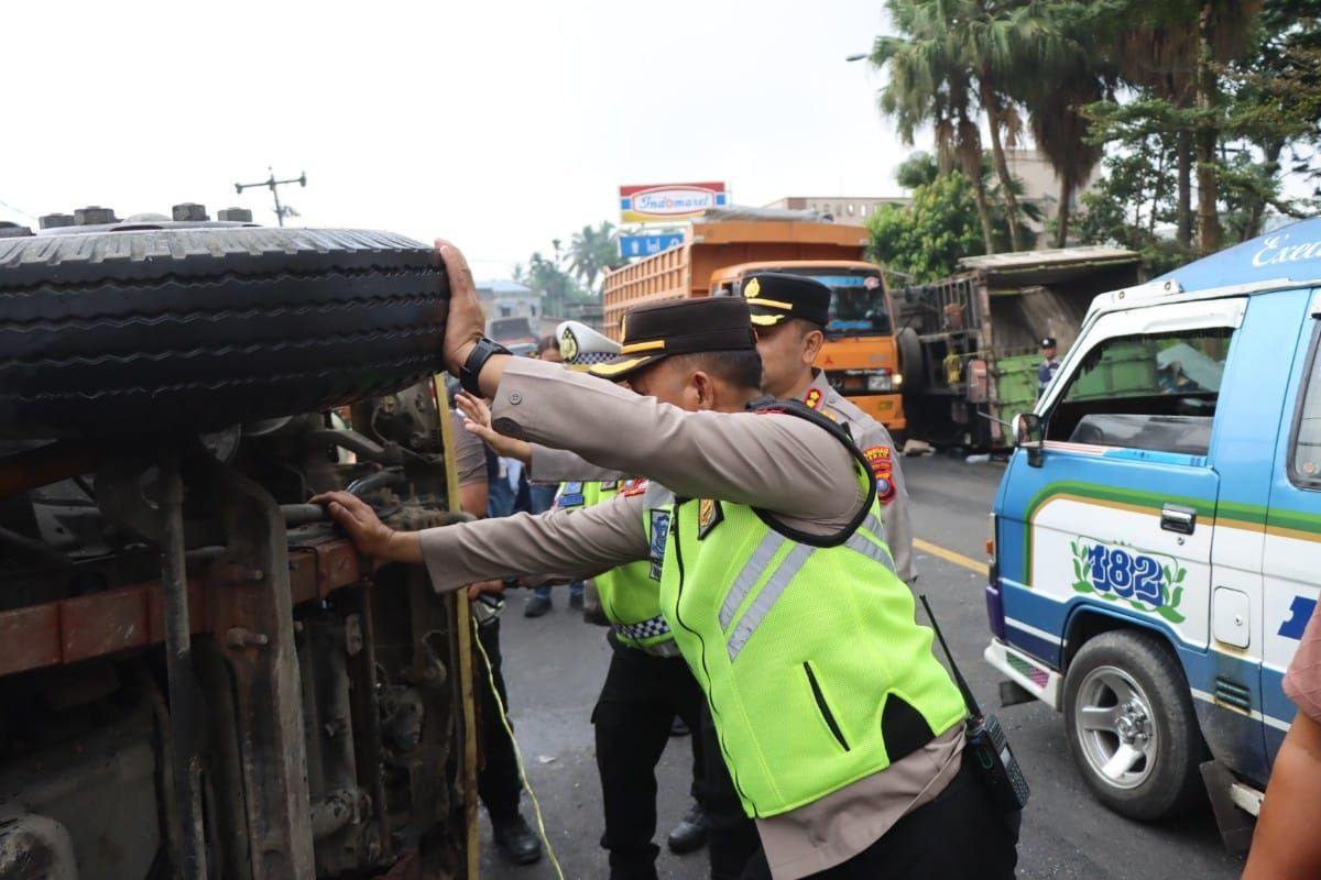 Police officers move a vehicle involved in a pileup on Friday on Jl. Jamin Ginting Km 45-44 in Suka Makmur village, Sibolangit district in Deli Serdang, North Sumatra. The accident happened after a truck carrying 5-gallon water jugs lost its braking system, hitting eight other vehicles, killing four people and injuring eight.
