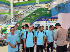 A police officer (right) registers Indonesians deported from Malaysia for various immigration violations on July 17 at Batam Center Ferry Terminal in Batam city, Riau Islands. The Indonesian Consulate General in Johor Bahru facilitated the repatriation of 90 Indonesians ahead of Independence Day on Aug. 17.