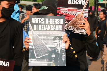 Protesters from a coalition of university students hold a banner reading &ldquo;Clean Up the Attorney General's Office&ldquo; during a demonstration outside the House of Representatives complex in Jakarta on July 10, 2026. The protesters called for an investigation into alleged corruption within the Attorney General's Office. 
