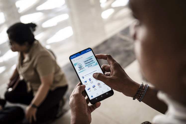 A man opens the Jateng Ngopeni Nglakoni application by the Central Java administration in his smartphone to access a free psychological consultation service in Semarang, Central Java, on July 3, 2026. The Central Java administration launched the app as an effort to early detect mental health issues among its residents, including children and students.