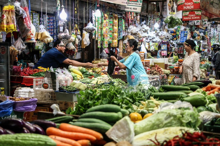 A vendor serves customers shopping for staple foods on June 11 at Kahayan Market in Palangka Raya, Central Kalimantan.