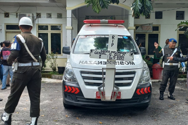 Two Indonesian Military police personnel stand near a hearse for the body of Genial Gavensi Gulo from Dr. Djasamen Saragih Regional Hospital in Pematangsiantar city, North Sumatra, on July 21, 2026. Genial allegedly committed suicide during enlisted basic training on July 20, at the Military Command (Kodam) I/Bukit Barisan&rsquo;s Main Regiment (Rindam) in Pematangsiantar. 