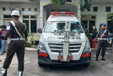 Two Indonesian Military police personnel stand near a hearse for the body of Genial Gavensi Gulo from Dr. Djasamen Saragih Regional Hospital in Pematangsiantar city, North Sumatra, on July 21, 2026. Genial allegedly committed suicide during enlisted basic training on July 20, at the Military Command (Kodam) I/Bukit Barisan&rsquo;s Main Regiment (Rindam) in Pematangsiantar. 