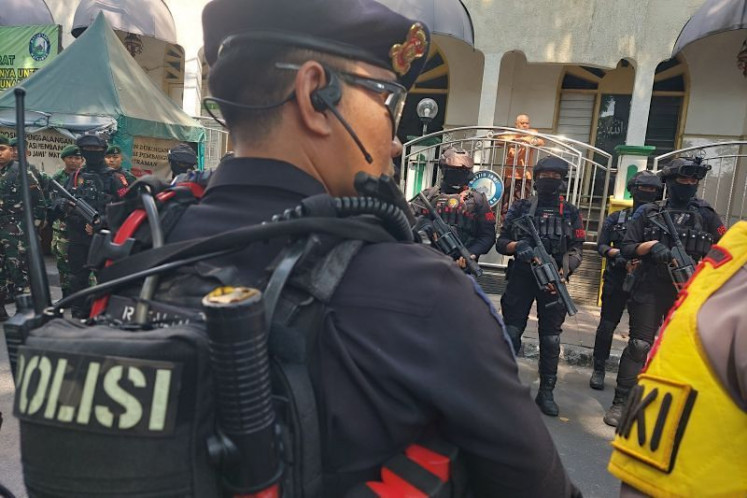 Police officers stand guard outside Jami Matraman Mosque on Matraman Dalam Street in Central Jakarta, on July 27, 2026. 