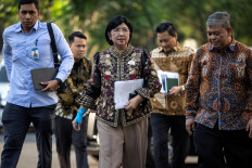 Interim Governor of&nbsp;Indonesia's Central Bank Destry Damayanti (center) arrives on July 27 at the Presidential Palace complex in Jakarta. 
