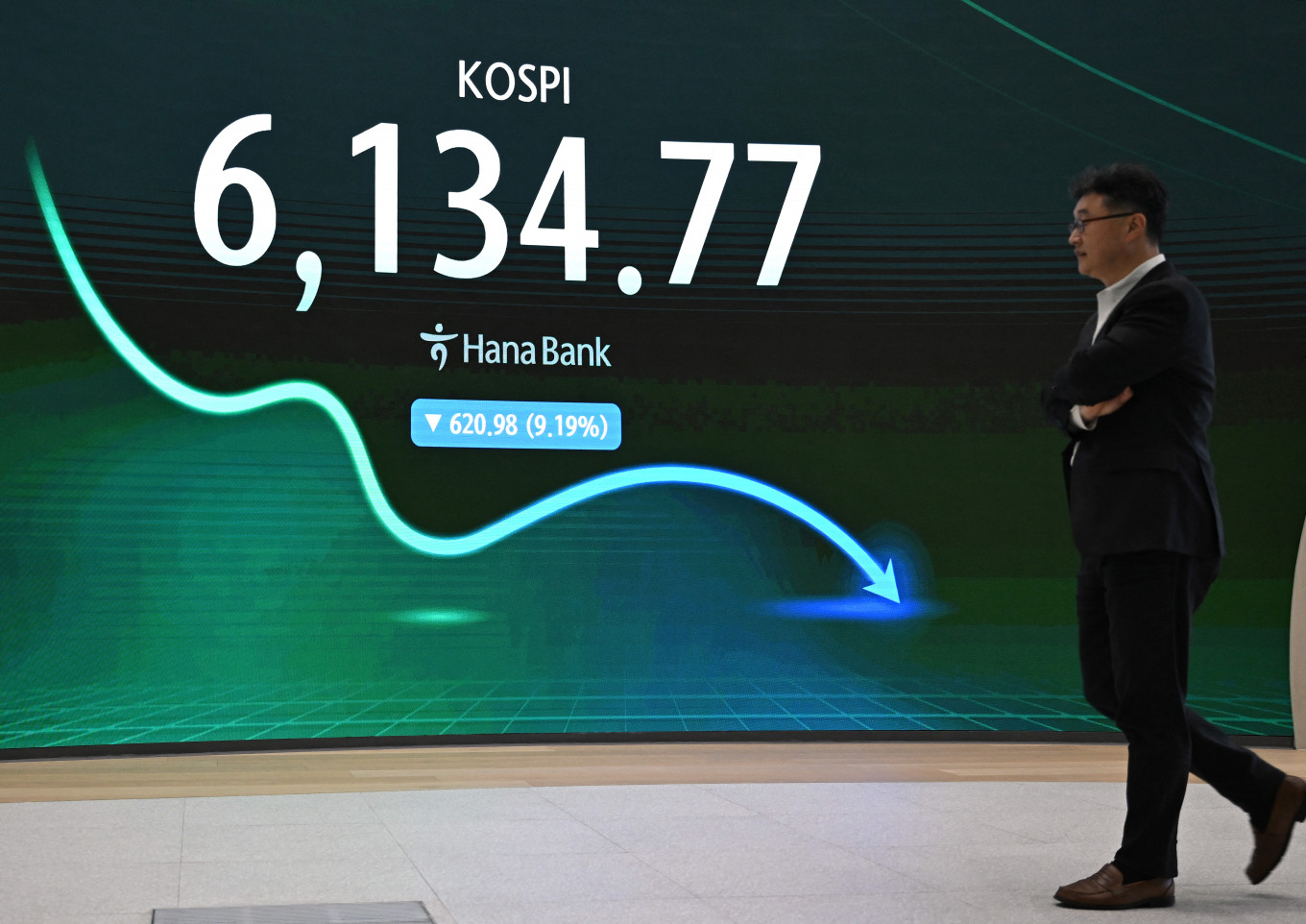 A man walks past an electronic screen showing South Korea's benchmark stock index (KOSPI) in a foreign exchange dealing room at the Hana Bank headquarters in Seoul on July 28, 2026.