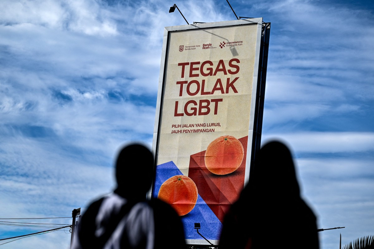 Pedestrians walk past a billboard that reads &ldquo;Firmly reject LGBT&ldquo;on July 27 in Banda Aceh, Aceh. Anti-LGBT sentiment is rising in Indonesia, with claims that food, vaccines and drugs can affect one's sexual orientation circulating online.