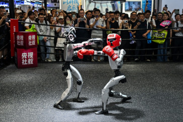 Humanoid robots controlled by a remote control by Unitree Robotics take part in a fight during the World Artificial Intelligence Conference (WAIC) in Shanghai on July 18, 2026.