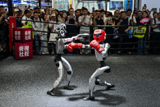 Humanoid robots controlled by a remote control by Unitree Robotics take part in a fight during the World Artificial Intelligence Conference (WAIC) in Shanghai on July 18, 2026.