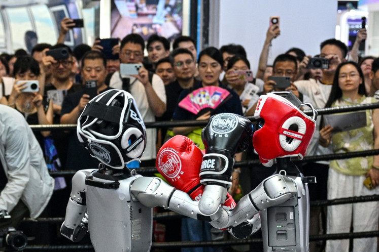Humanoid robots controlled by a remote control by Unitree Robotics take part in a fight on July 18 during the World Artificial Intelligence Conference (WAIC) in Shanghai.