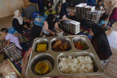 Workers prepare meal packages to be distributed to pregnant women, nursing mothers and toddlers under the free nutritious meal program on July 30 in Batam, Riau Islands.