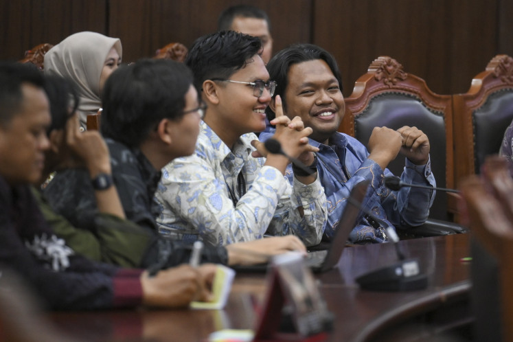 Plaintiffs Muhammad Jundi Fathi Rizky (right) and Dzakwan Fadhil Putra Kusuma (second right) smile during the ruling hearing for the judicial review petition against the education budget allocation for the free nutritious meal program at the Constitutional Court in Jakarta on July 30, 2026. The court ruled the free meal funding under the education allocation of the 2026 state budget inconstitutional and ordered the government to exclude the program from educational expenses by the 2028 state budget, at the latest.