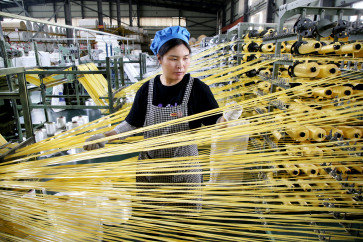 A worker monitors products for export at a packaging factory in Lianyungang, in China's eastern Jiangsu Province, on May 18, 2026.