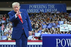 United States President Donald Trump gestures on July 22, 2026, as he arrives onstage to speak at Wheeler High School in Marietta, Georgia.