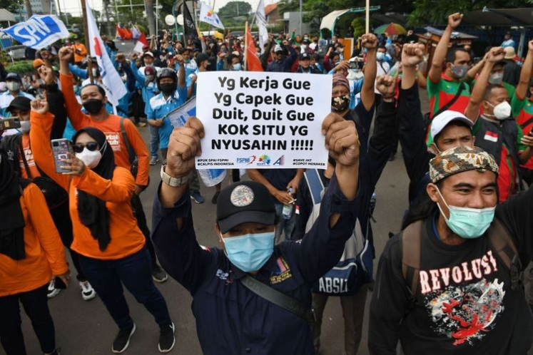 Dozens of workers rally on Feb. 18, 2022, outside the Manpower Ministry on Jl. Gatot Subroto in South Jakarta to demand it cancel a ministerial regulation stipulating a minimum age of 56 for people to start withdrawing from their pension funds. 