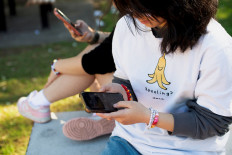 A 15-year-old girl poses while holding a mobile phone in Sydney, Australia, on July 14, 2026.