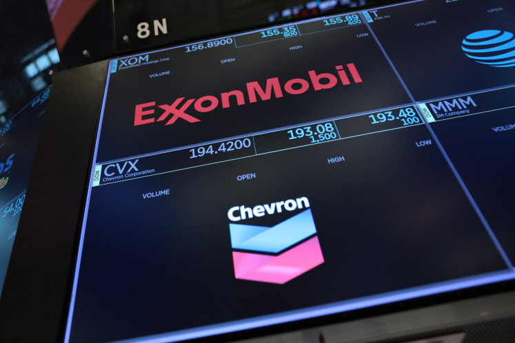 The logos of ExxonMobil and Chevron are displayed on the floor of the New York Stock Exchange during morning trading on July 24, 2026, in New York City, United States.