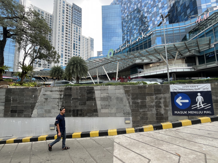 A visitor walks past a wall at the entrance of Kota Kasablanka shopping mall on Sunday in South Jakarta. A tall metal fence that had previously been installed in front of the mall's entrance and exit had been removed, based on observations made at the scene at about 11 a.m.