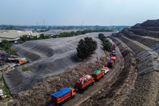 Garbage trucks line up near mounds of waste covered with protective sheeting on Aug. 2 at the Bantar Gebang Integrated Waste Management Site in Bekasi, West Java. The Jakarta administration began gradually implementing a controlled landfill system at the facility on Aug. 1 as part of its plan to phase out open dumping, aiming to improve waste management while reducing the risk of fires and foul odors.