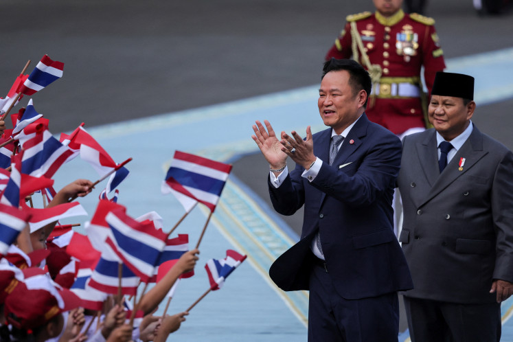 Thailand's Prime Minister Anutin Charnvirakul applauds next to President Prabowo Subianto as they are greeted by elementary school children waving Thai and Indonesian flags, during a welcome ceremony in Jakarta on August 3, 2026.