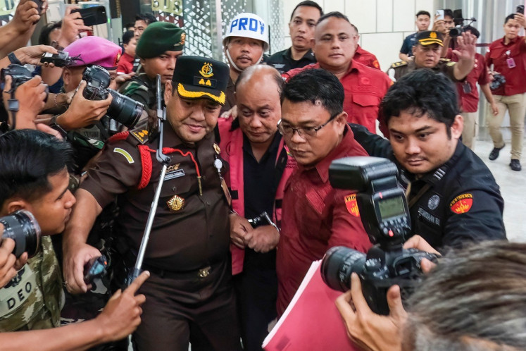 Dadan Hindayana (center), former head of the National Nutrition Agency (BGN) that oversees the free nutritious meal program, is escorted by Attorney General's Office (AGO) officers and Indonesian Military personnel on June 3 as he leaves the AGO building in Jakarta. The AGO named Dadan and two former BGN deputies as graft suspects pertaining to the procurement and partnering foundation appointment for the program, a day after they were removed over concerns including food quality. 