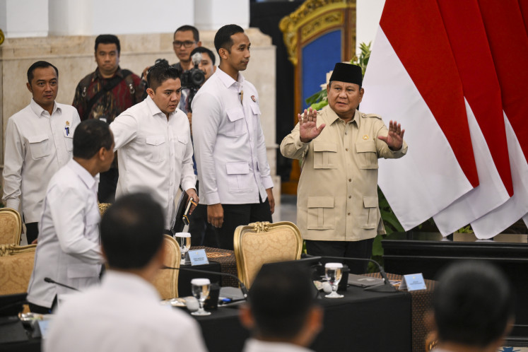 President Prabowo Subianto (right) gestures on Friday as he enters the State Palace for a meeting with Chamber of Commerce and Industry (Kadin) members.