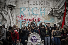 Protesters gather before a monument with graffiti that reads &ldquo;tax the rich&rdquo; on Sept. 10, 2025, during a rally held as part of the &ldquo;Bloquons tout&ldquo; (Let's block everything) protest movement at Place de la R&eacute;publique in Paris.