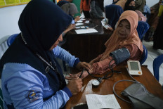A health worker examines a female patient's blood pressure on July 17 during the free health screening at the Mandonga subdistrict office in Kendari, Southeast Sulawesi. More than 73 million people nationwide received free screenings in the first seven months of 2026, according to the Health Ministry.