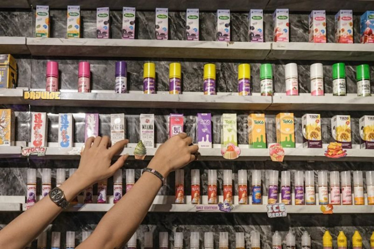 A vendor arranges bottles of e-cigarette, or vape, liquids at a shop in Kendari, Southeast Sulawesi, on April 8, 2026. 