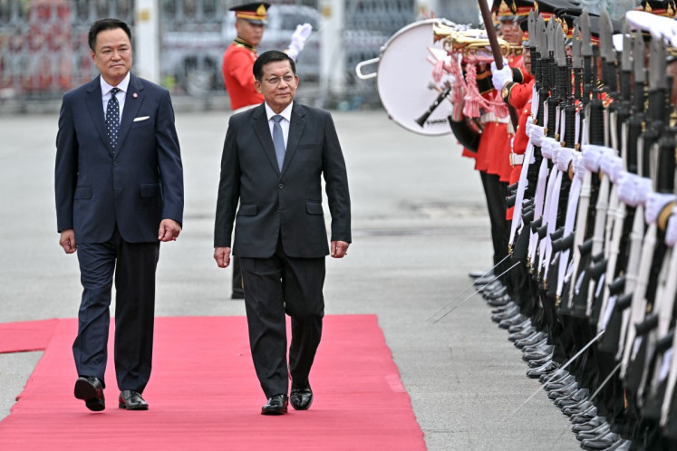 Myanmar's junta chief turned President Min Aung Hlaing (center) and Thailand's Prime Minister Anutin Charnvirakul (left) inspect a guard of honor at a welcoming ceremony during his visit at Government House in Bangkok on August 6, 2026.
