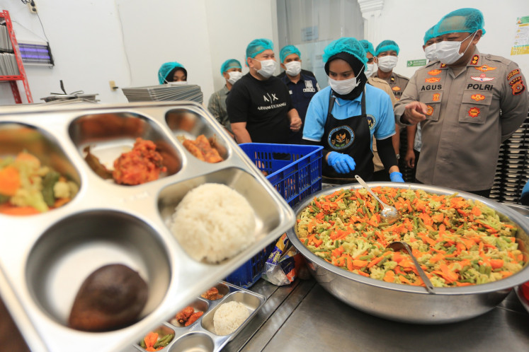 West Aceh Police chief Adj. Sr. Comr. Agus Sulistianto (right) inpects the food preparation for the free nutritious meal program at a kitchen managed by the West Aceh Police in West Aceh regency, Aceh on Aug. 6, 2026. The National Nutrition Agency (BGN) requires all free meal kitchen to have hygiene and sanitation certificates (SLHS) by Aug. 10 to avoid permanent closure.