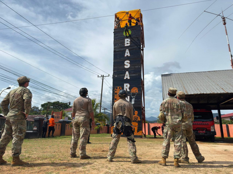 Guardsmen from the Hawaii Army National Guard's 7th Engineer Battalion observe as Indonesian first responders scale down a giant wall to simulate vertical rescue during the Pacific Partnership 2026 exercise at the Sibolga Search and Rescue Agency (SAR) office in Pandan, Central Tapanuli, North Sumatra, on July 24, 2026. The disaster mitigation exercise also included water rescue and  a table-top exercise on disaster response.
