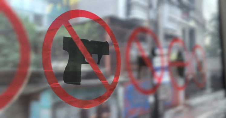A no weapons sign is seen on the window inside a Transjakarta bus in this undated photo.