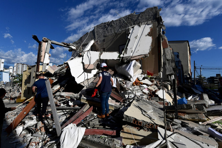 Rescuers look for survivors amid the rubble of a collapsed building after an earthquake in Pereira, Colombia on August 10, 2026. A magnitude 7.4 earthquake struck Colombia on August 10, 2026, and killed at least 111 people, damaged more than 1,500 buildings, and left an unknown number of people buried under rubble. 