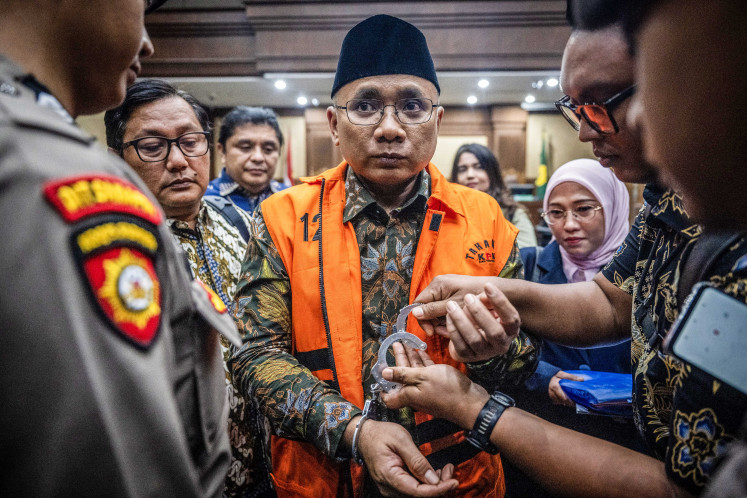Graft defendant Yaqut Cholil Qoumas (center) is handcuffed on Tuesday, Aug. 11, 2026, after a court hearing to read the indictment in a Haj quota corruption case at the Jakarta Corruption Court. Corruption Eradication Commission (KPK) prosecutors accused the former religious affairs minister of causing Rp 622 billion (US$38.6 million) in state losses.