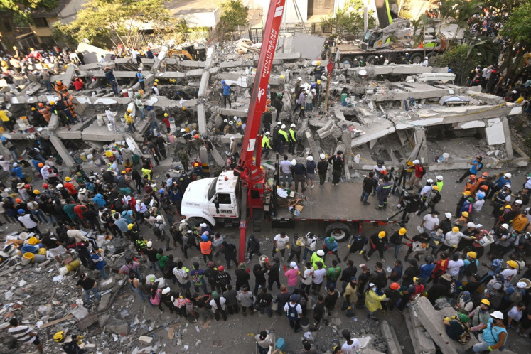 Rescuers and volunteers search for survivors amid the rubble of a collapsed building after an earthquake in Cali, Colombia on August 11, 2026. Colombian volunteers and rescuers cleared rubble with their bare hands to search for survivors early on August 11 after the country's strongest earthquake in a decade killed at least 169 people and smashed dozens of buildings.