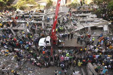Rescuers and volunteers search for survivors amid the rubble of a collapsed building after an earthquake in Cali, Colombia on August 11, 2026. Colombian volunteers and rescuers cleared rubble with their bare hands to search for survivors early on August 11 after the country's strongest earthquake in a decade killed at least 169 people and smashed dozens of buildings.