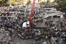 Rescuers and volunteers search for survivors amid the rubble of a collapsed building after an earthquake in Cali, Colombia on August 11, 2026. Colombian volunteers and rescuers cleared rubble with their bare hands to search for survivors early on August 11 after the country's strongest earthquake in a decade killed at least 169 people and smashed dozens of buildings.