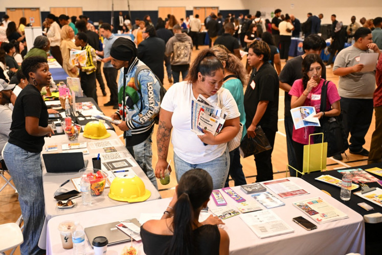 Job seekers browse information tables as they attend a Inspire Together job and resource fair in Los Angeles, California on July 29, 2026. The US Federal Reserve held interest rates steady on Wednesday, with surging inflation fueled by President Donald Trump's war on Iran seeing three of the committee's 12 policymakers calling for a quarter-percentage-point rate hike.